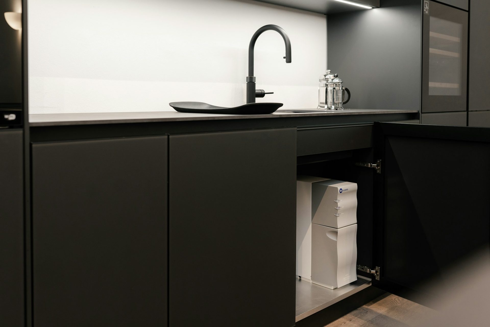 Compact kitchenette with integrated sink, benchtop and concealed storage