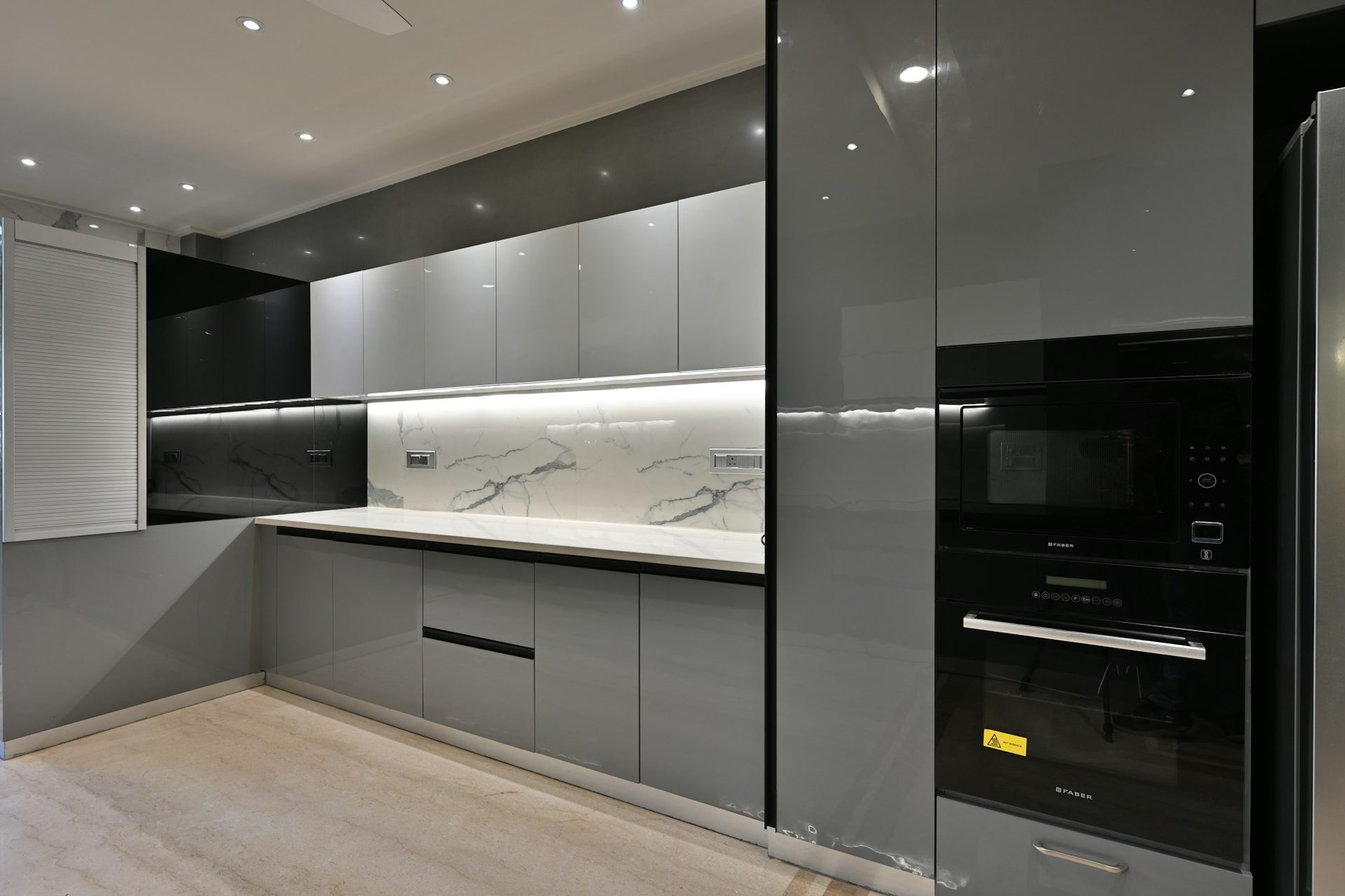 Dark gloss kitchen joinery with integrated ovens