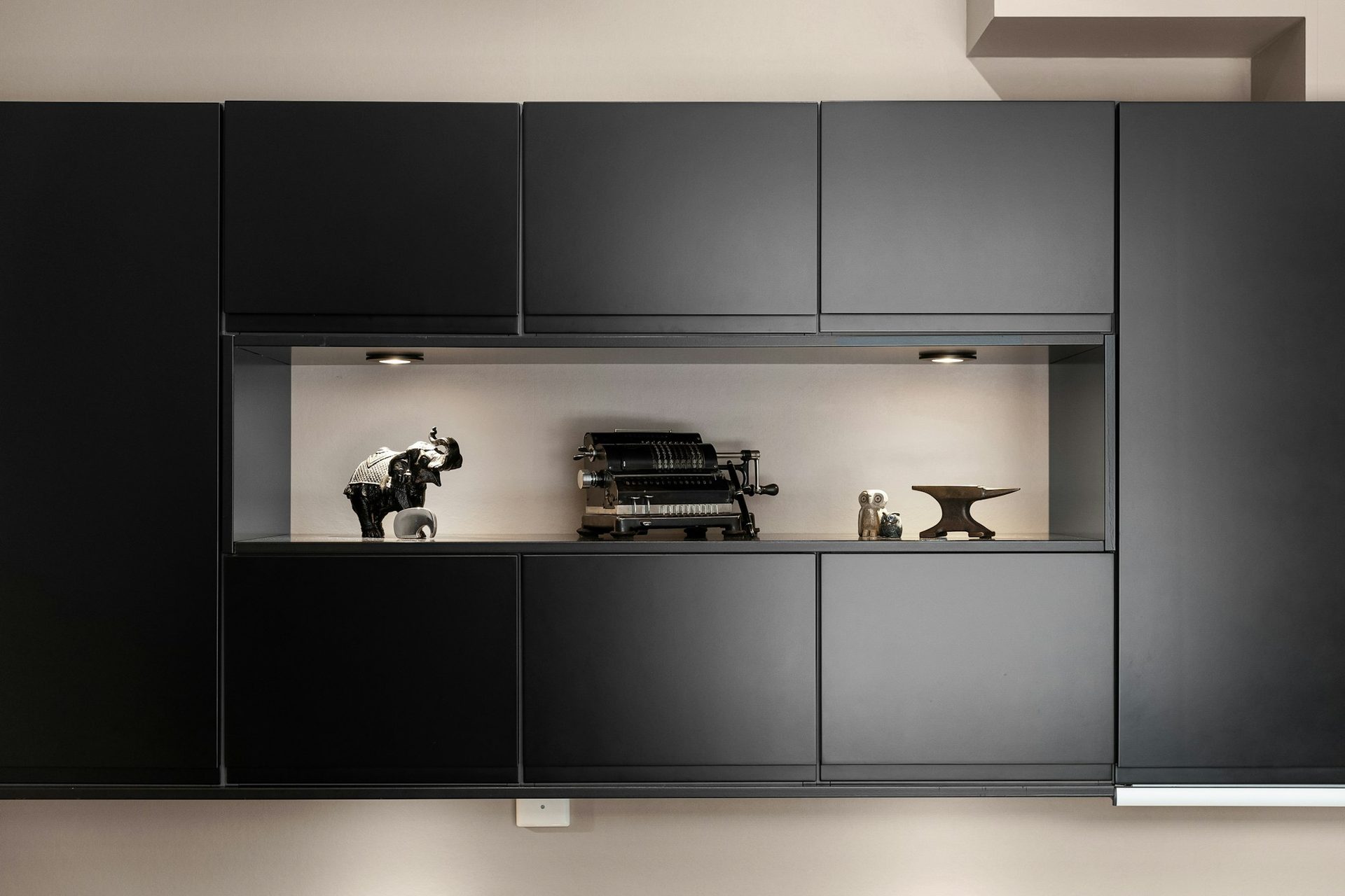 Matte black handleless kitchen cabinetry with integrated appliances