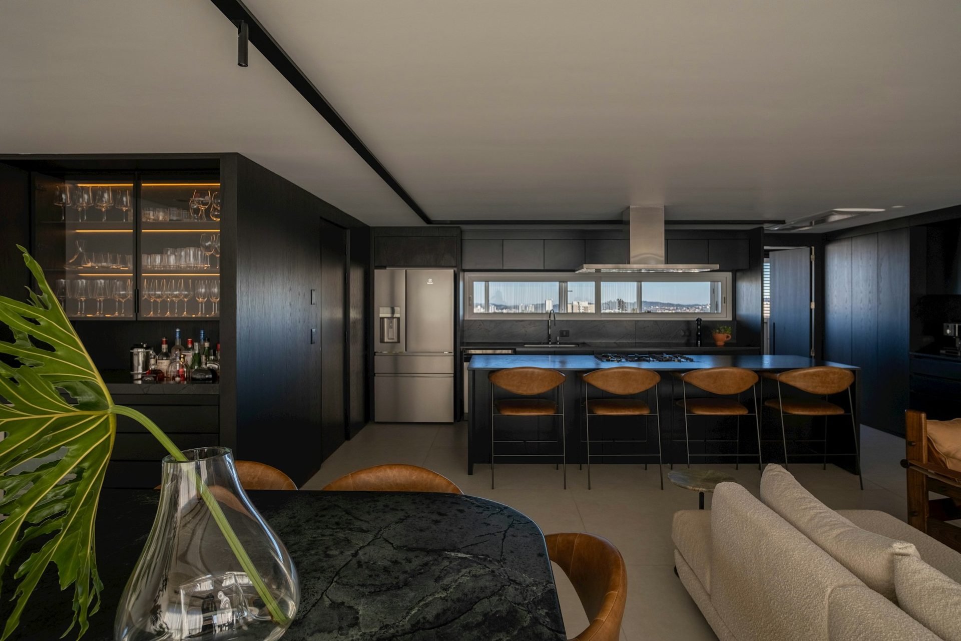 Dark bespoke kitchen with feature stone island and leather bar seating